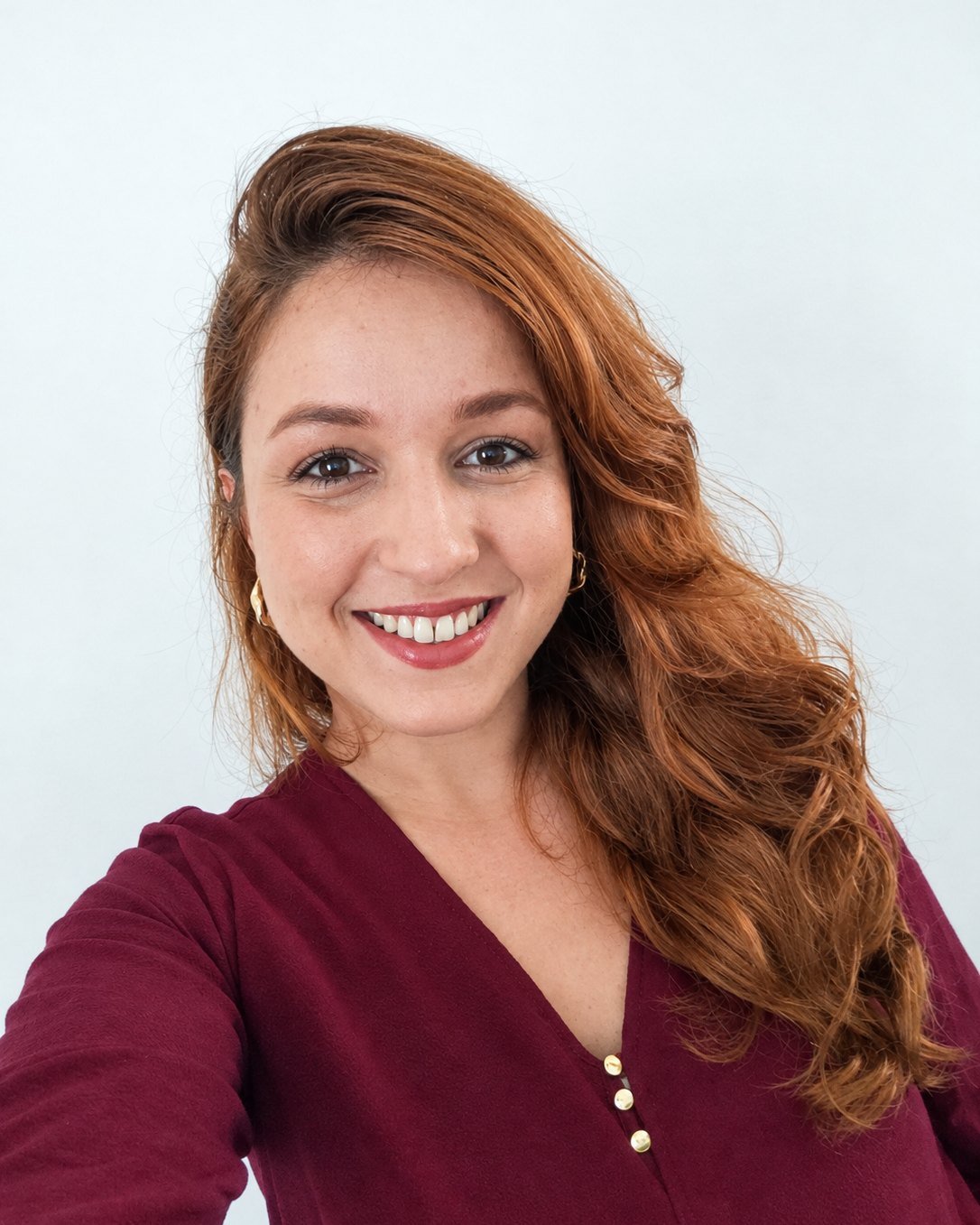 Retrato de Stefani Rafaeli Zopellaro sorrindo, de blusa vinho, em fundo claro